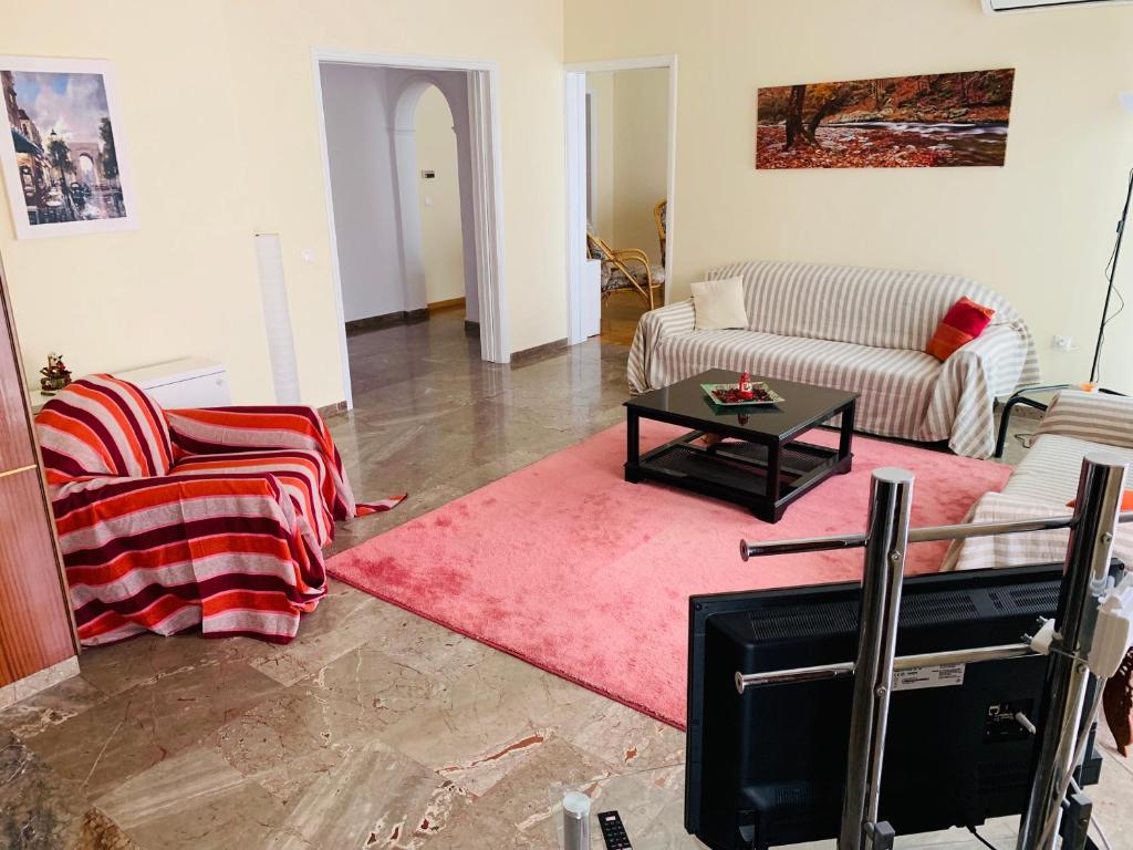 uma sala de estar com um sofá e uma mesa em Apartment in Markopoulo center em Markopoulon