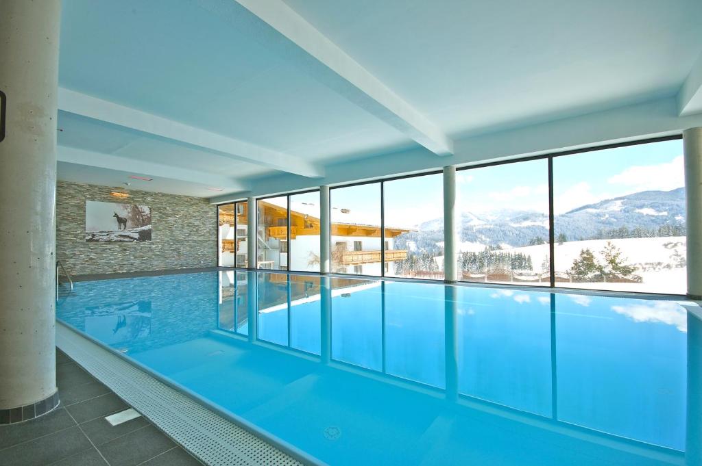 a swimming pool with a view of the mountains at Alpin Apart in Flachau