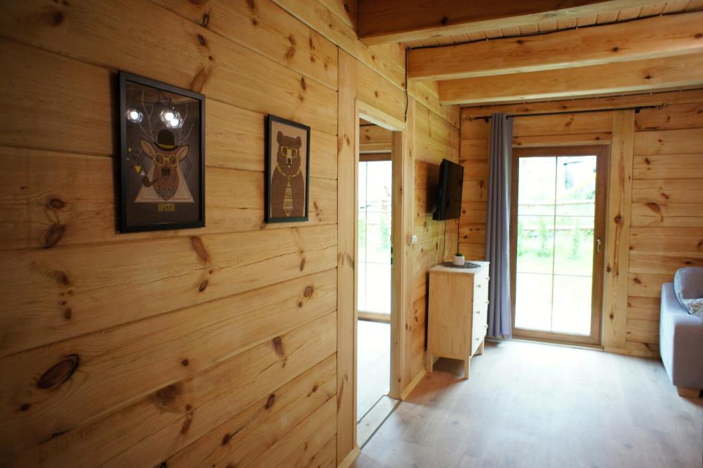 ザブスにあるPrzystań Bieszczadyの木製の壁とスライドドアのあるリビングルーム