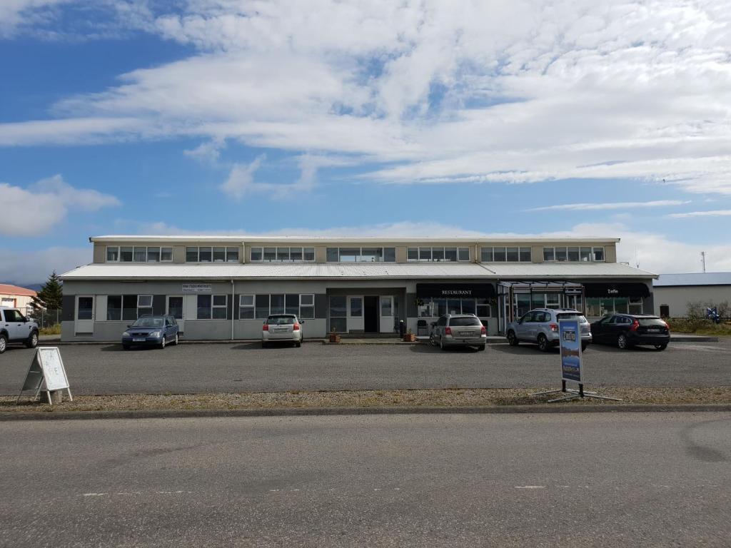 un gran edificio con coches estacionados en un estacionamiento en Díma Studio Apartments en Höfn