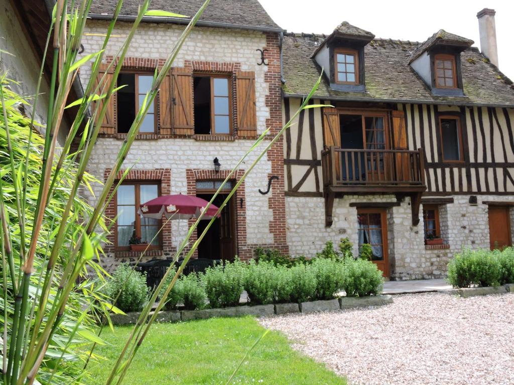 une maison ancienne avec un jardin en face dans l'établissement Gîte de la Ferme de la Côte, à Les Damps