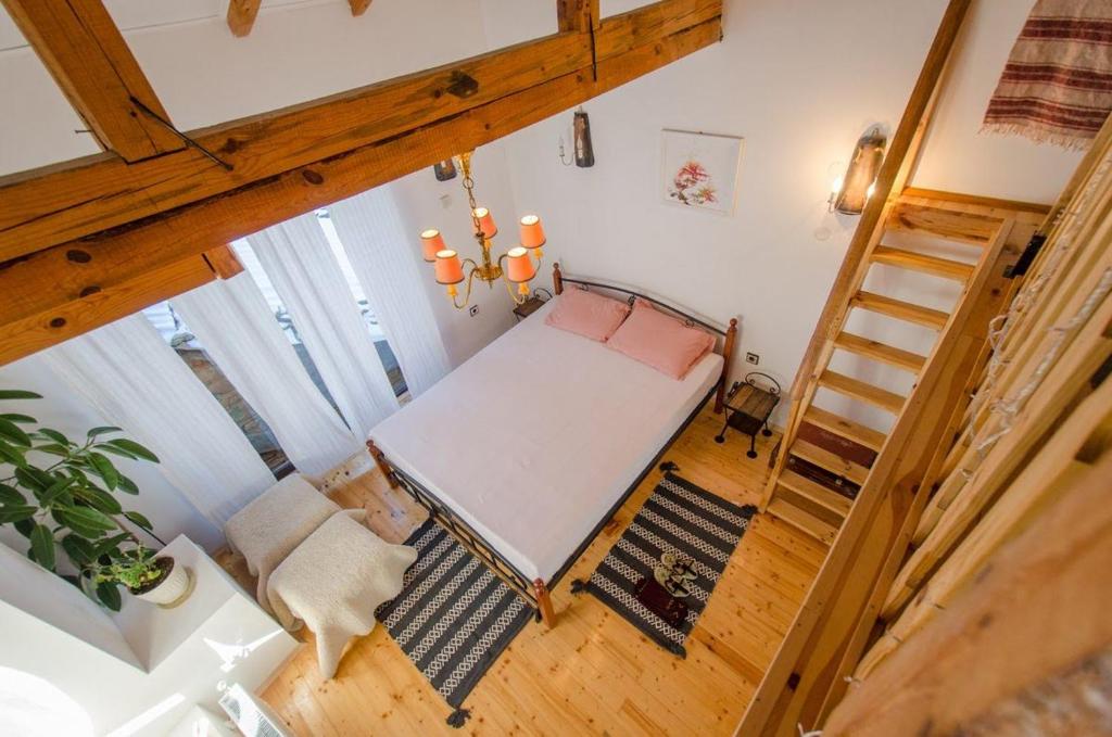 an overhead view of a bedroom with a bed and a ladder at Къща за гости ЧИЧАРИТЕ in Gabrovo