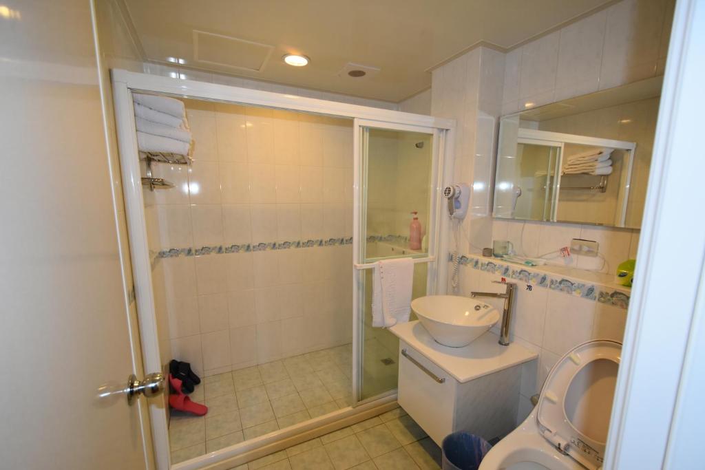 a bathroom with a shower and a toilet and a sink at Shi-Jia B&amp;B in Jiufen