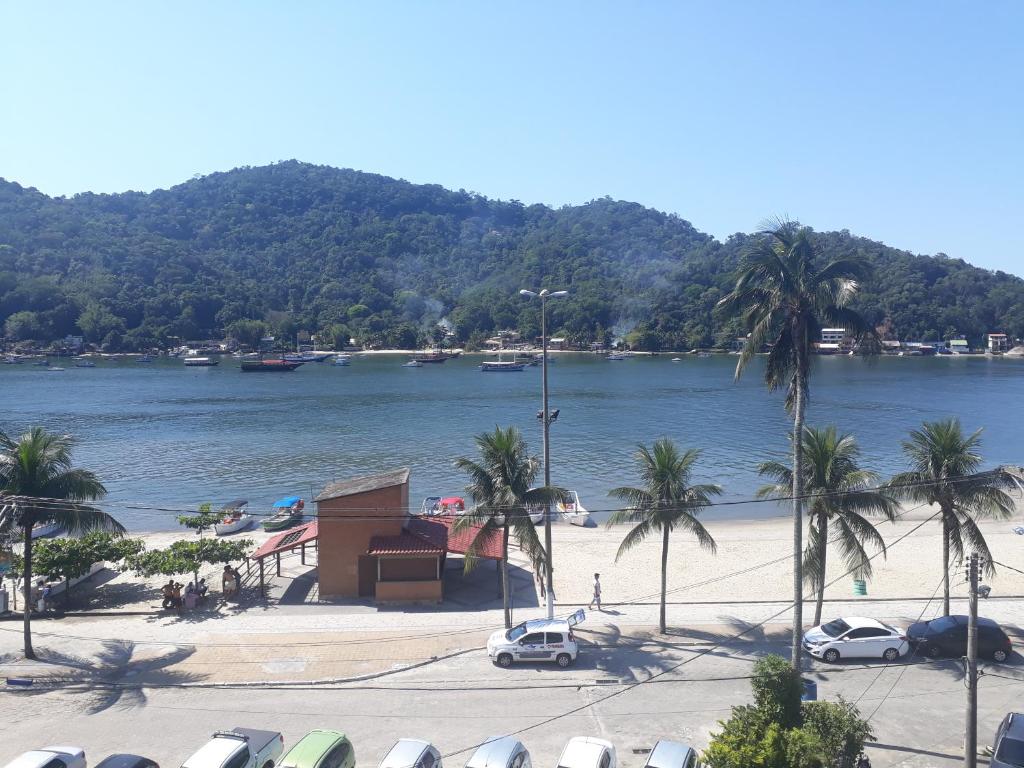 una spiaggia con palme e una bacinella d'acqua di Itacuruçá Inn a Itacuruçá