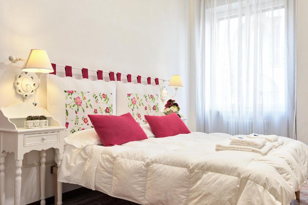 a bedroom with a large white bed with red pillows at Stay Bergamo in Bergamo