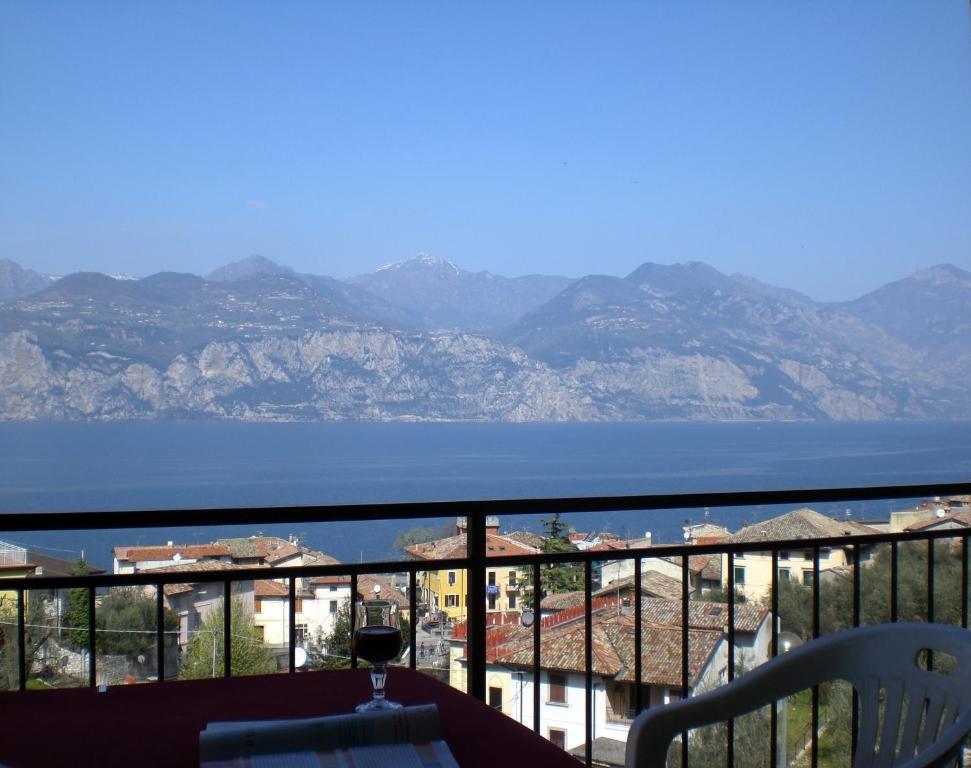 een balkon met uitzicht op het water en de bergen bij New Piccolo Residence in Malcesine