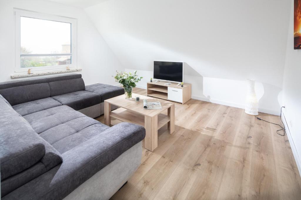 a living room with a couch and a tv at Deniz - Blick in Norderney