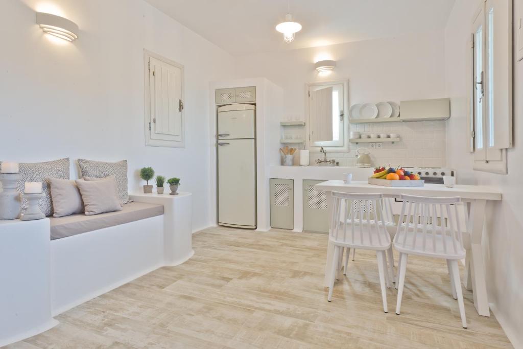 a white kitchen with a table and two chairs at Lux View Villas in Kyra Panagia