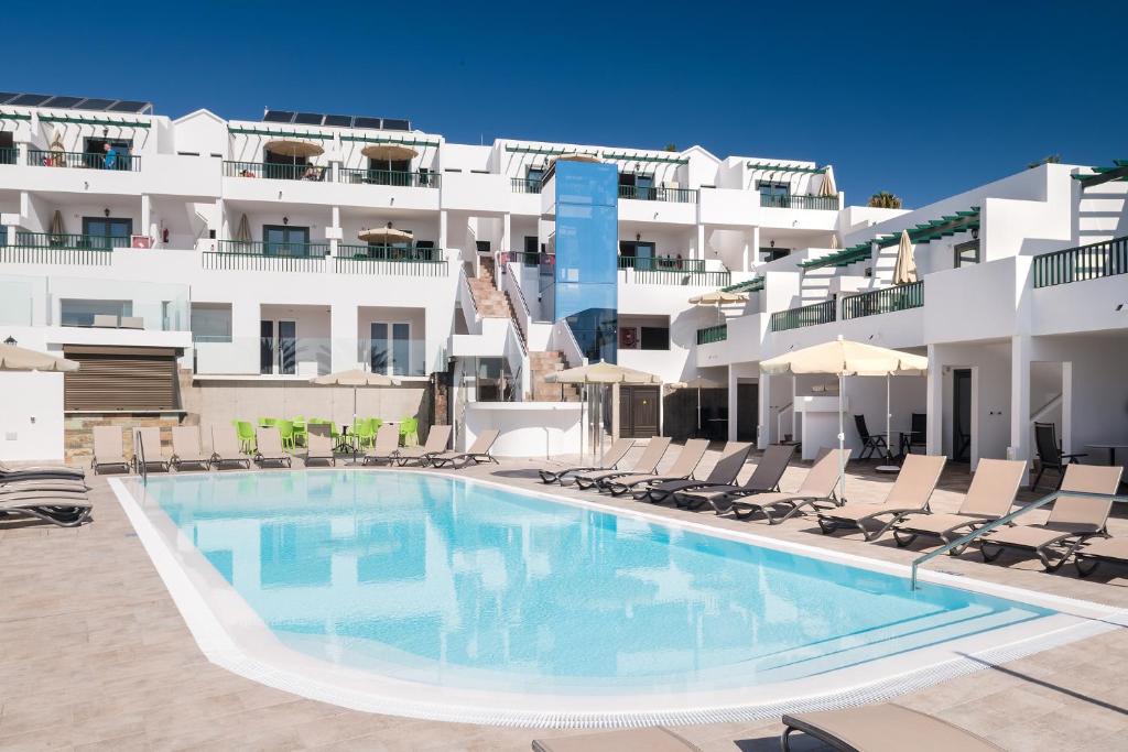 a swimming pool in front of a building at Apartamentos Villa Canaima in Puerto del Carmen