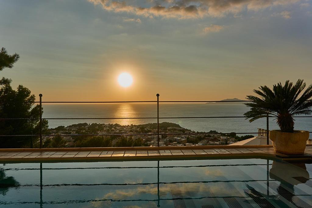 a pool with a view of the ocean at sunset at Monte Solaro Bed & Breakfast in Anacapri