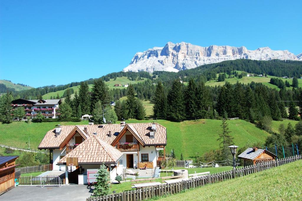 una casa con una valla y una montaña en el fondo en Chalet alla Cascata, en Badia