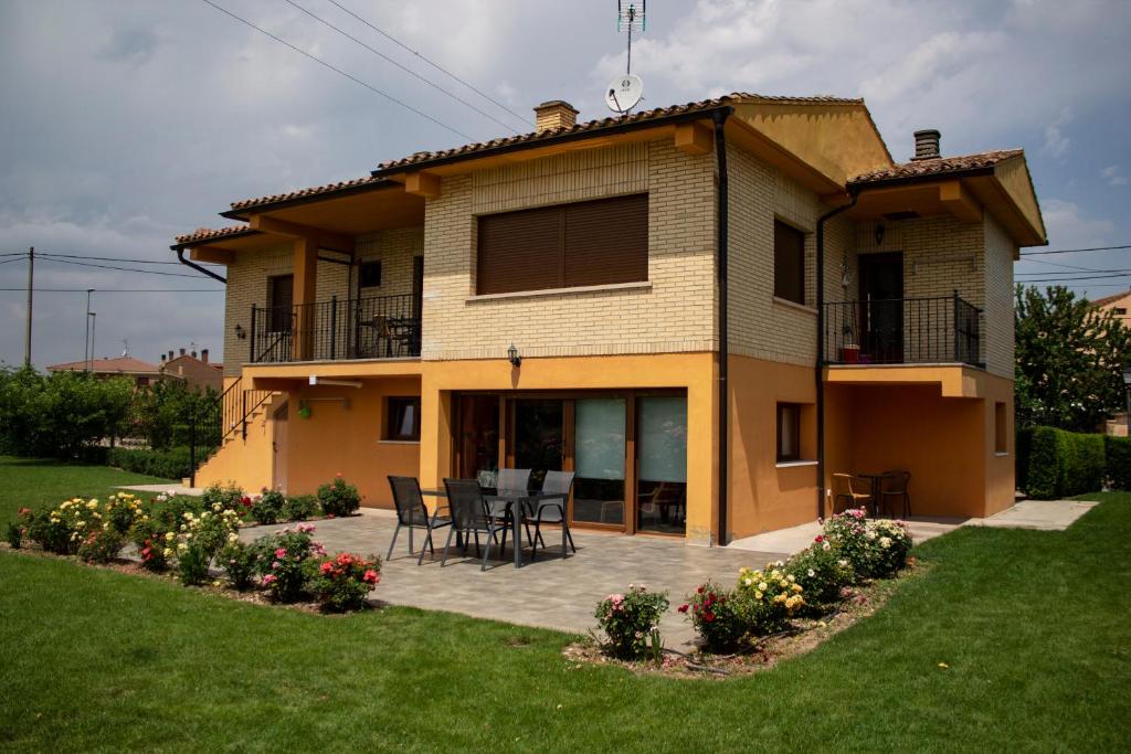 a house with a table and chairs in a yard at La Cueva del Tempranillo in Huércanos