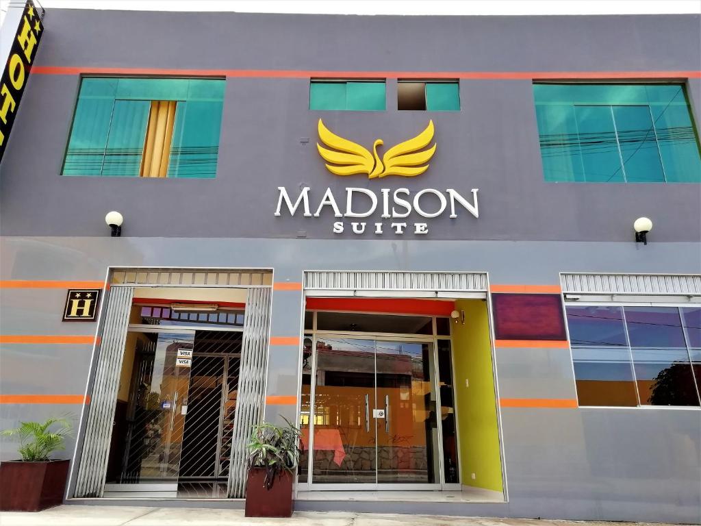 Un edificio con un cartello di Madison Suite. di Madison Suite a Tacna