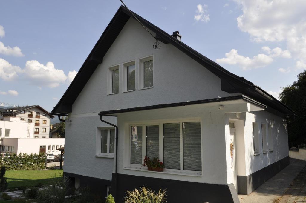 ein weißes Haus mit schwarzem Dach in der Unterkunft Apartmány CENTRUM in Rajecké Teplice