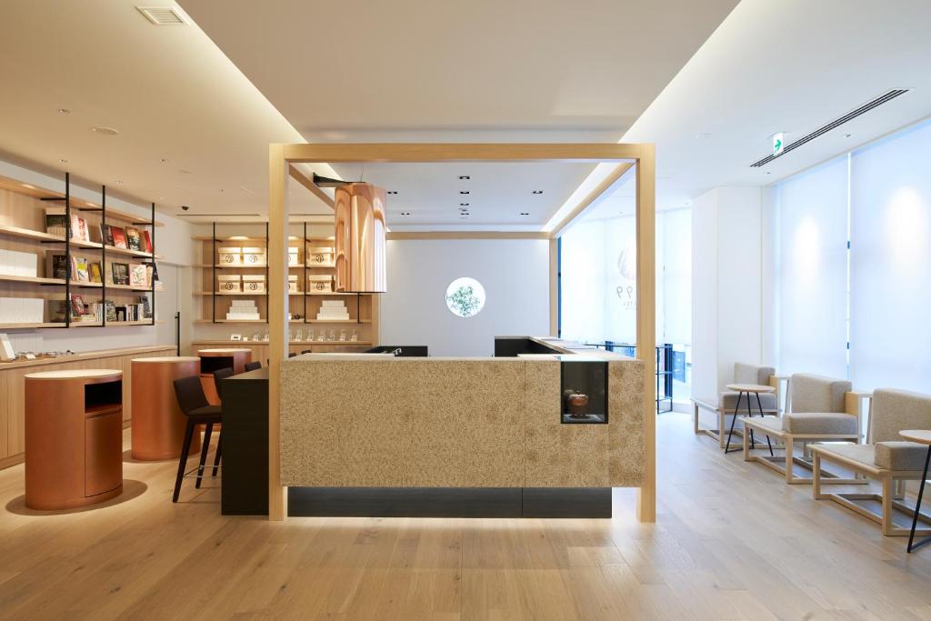 a lobby with a counter and tables and chairs at HOTEL 1899 TOKYO in Tokyo