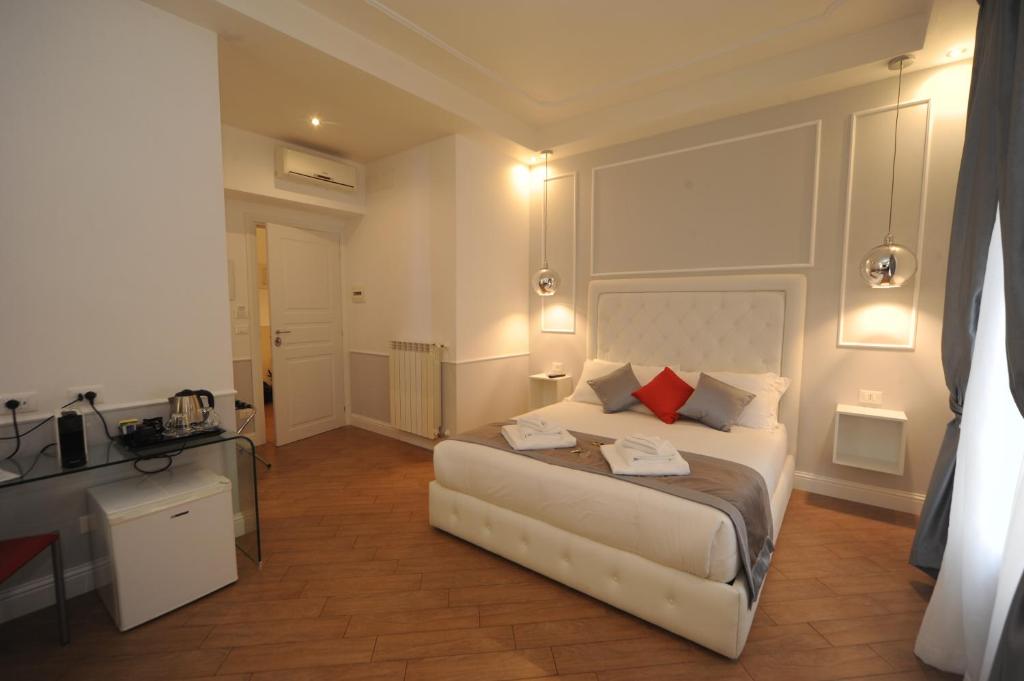 a bedroom with a white bed with red pillows at My Suites Piazza di Spagna in Rome