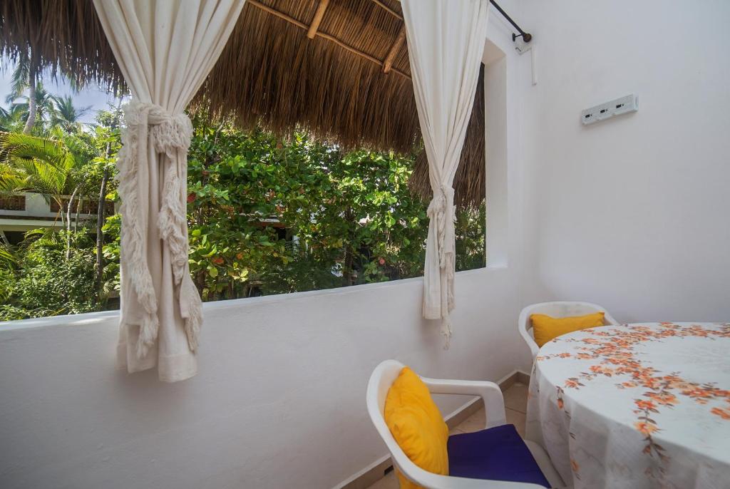 um quarto com uma janela com uma mesa e cadeiras em Casa Silvana - Villas del Palmar em Sayulita