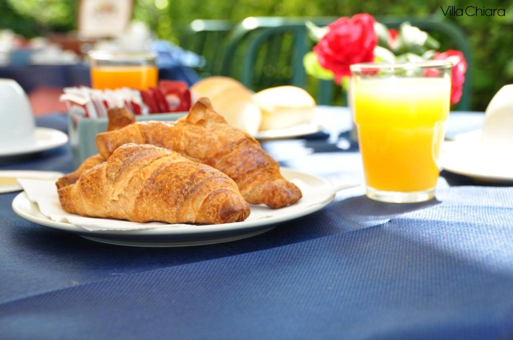 a plate of bread and a glass of orange juice at Villa Chiara in Lazise