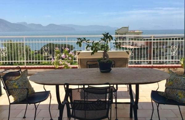 einen Tisch mit Stühlen und eine Topfpflanze auf dem Balkon in der Unterkunft La Casa di Marcello in Torre Annunziata
