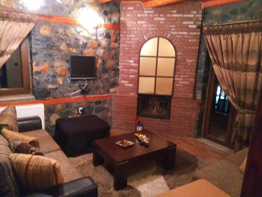 a living room with a couch and a fireplace at Anesis Suites in Palaios Agios Athanasios