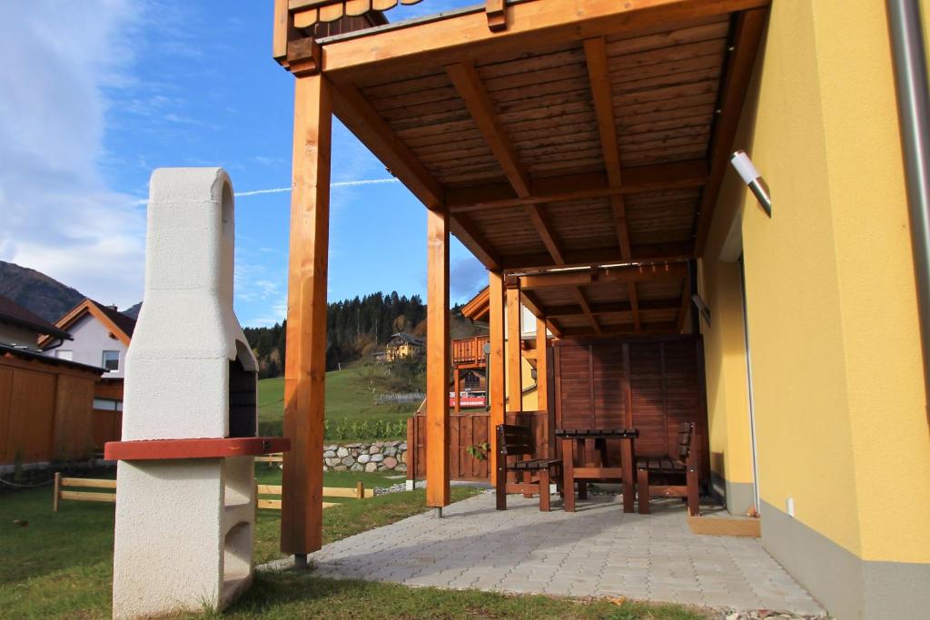 a wooden pergola on the side of a building at Chalet Underhill in Kötschach