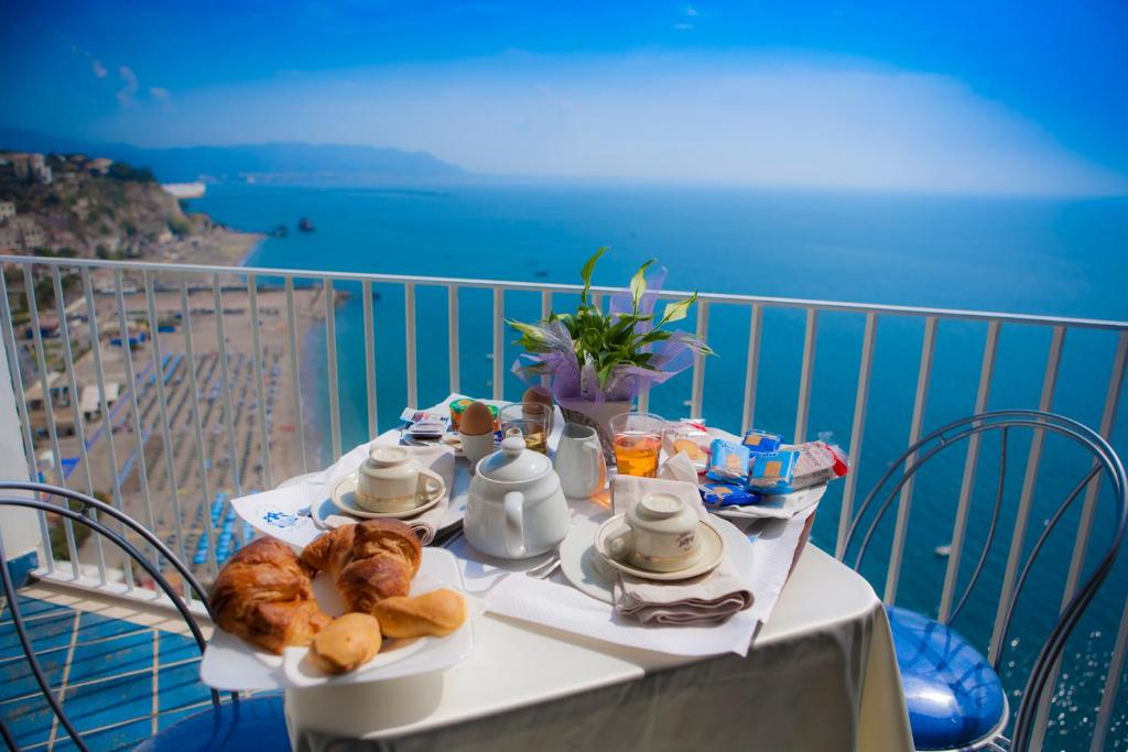 a table with food on it with a view of the ocean at Hotel Voce del Mare in Vietri sul Mare