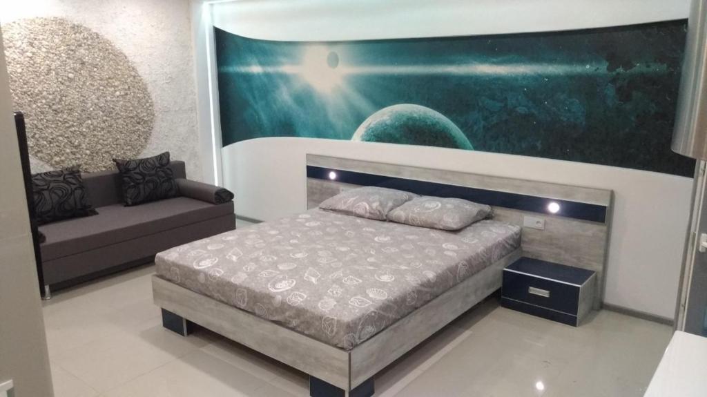 een slaapkamer met een bed en een bank erin bij Falcon-X apartment in Nikolayev