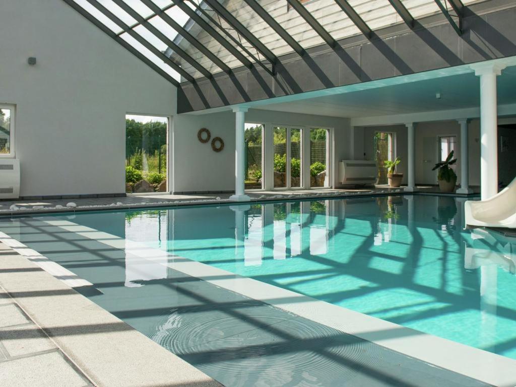 an indoor swimming pool with a glass ceiling at Thermes Oppidum in Theux