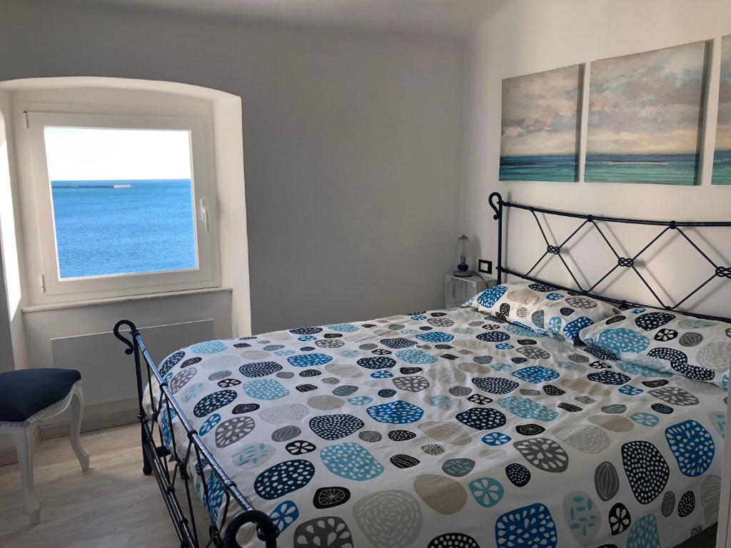 una camera con letto e vista sull'oceano di La Casetta di Dory sul Mare a Genova