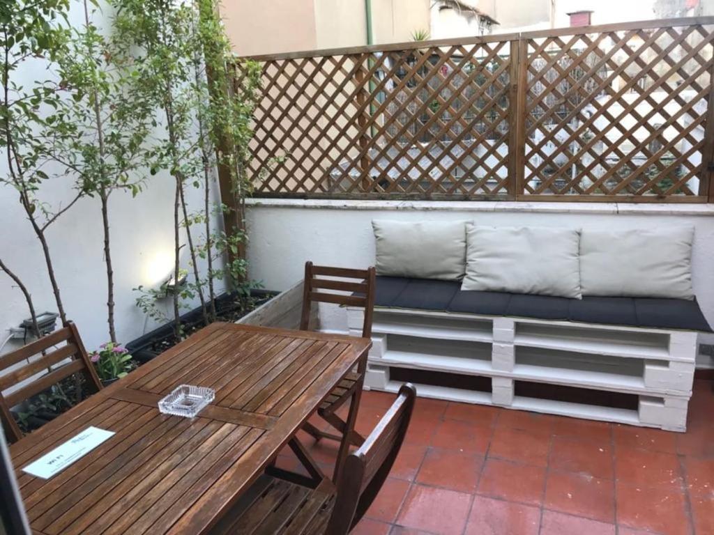 a patio with a bench and a table and chairs at Flat with Terrace in Adamastor in Lisbon