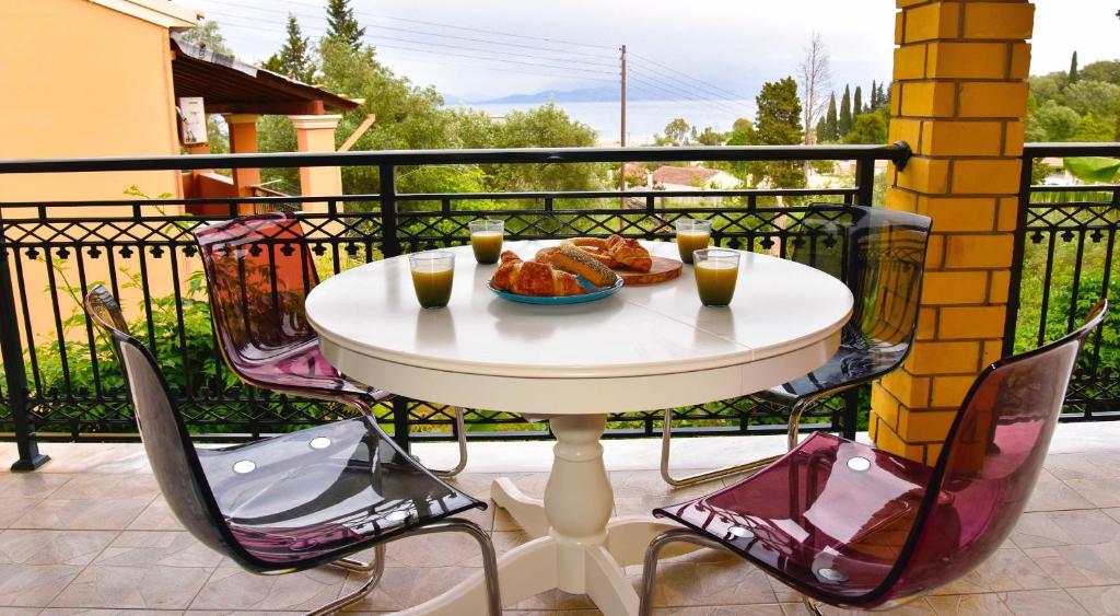 a white table with two drinks and food on a balcony at Corfu Villa Levanta in Kontokali