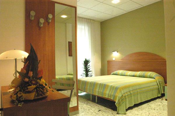 - une chambre avec un lit et un miroir dans l'établissement B&B Vittoria, à Maiori