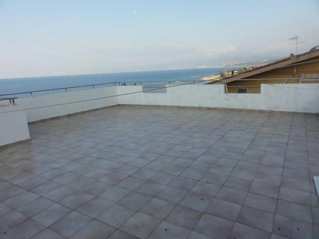 a large patio with the ocean in the background at Acqualadroni Affitti in Aquarone