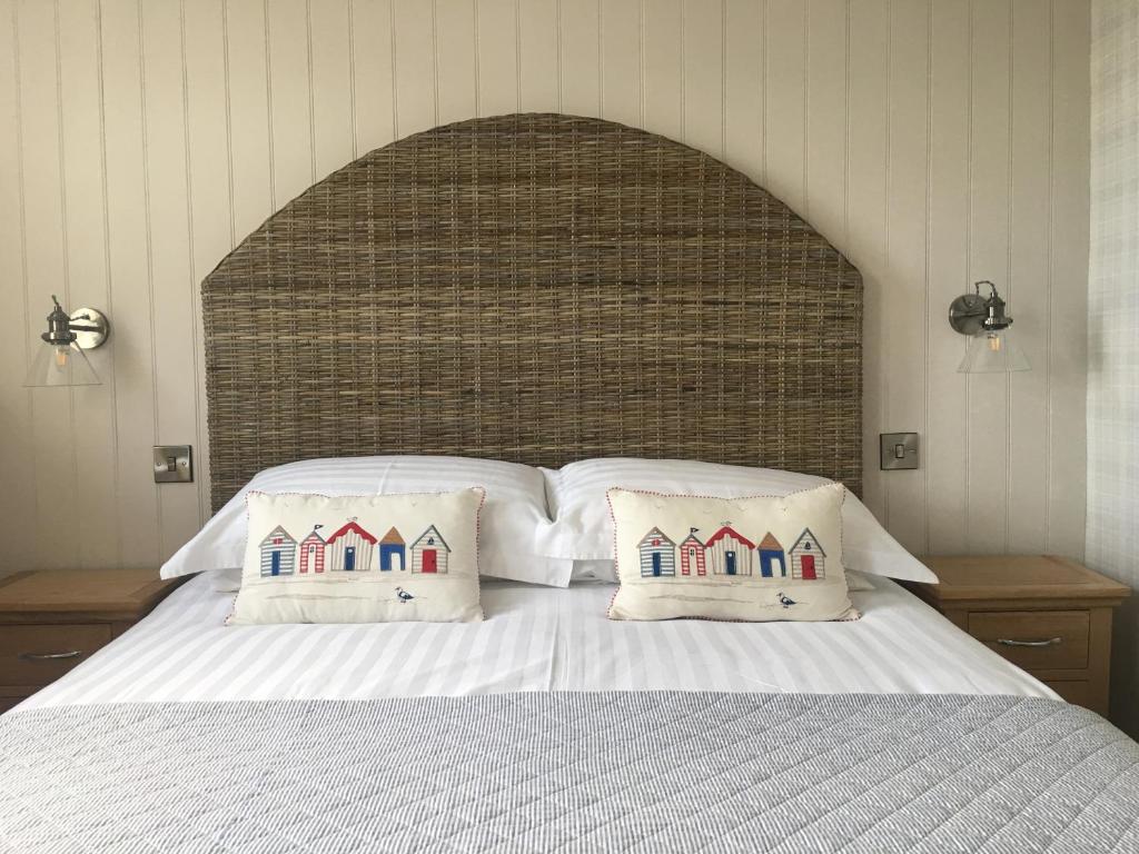 a bedroom with a large bed with two pillows at Woodlands Guest House in Saundersfoot