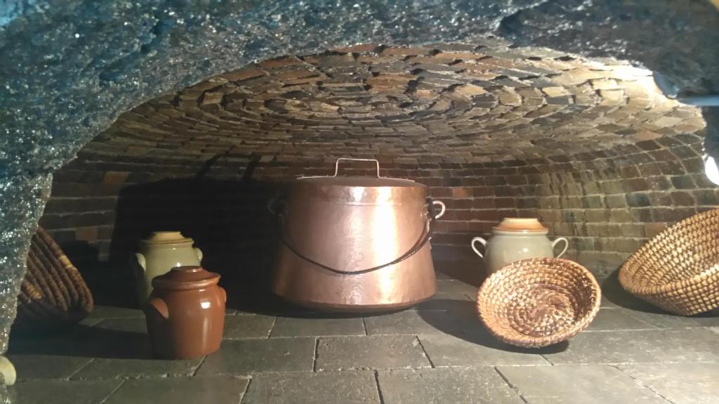 una olla y otros artículos en un horno de ladrillo en Location Insolite Dans Un Four A Pain, en Saint-Étienne-de-Carlat