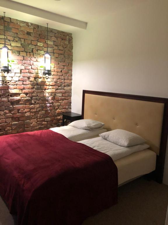 a bedroom with a bed with a brick wall at Flores Apartament in Katowice