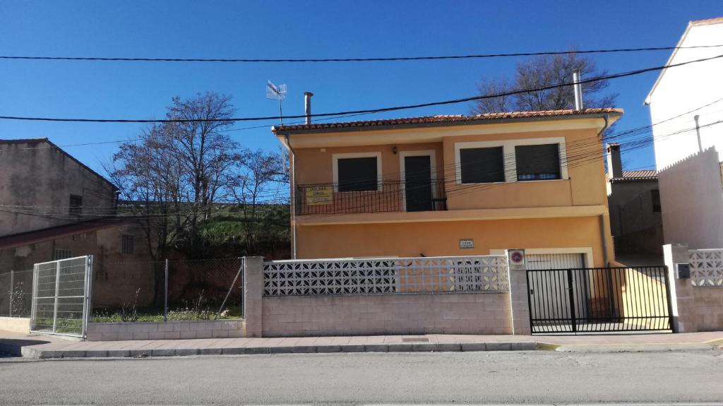 una casa amarilla con una valla delante de ella en Apartamentos Rurales Carlos, en Barracas