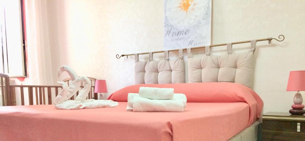 ein Schlafzimmer mit einem rosa Bett mit Handtüchern darauf in der Unterkunft Alloggio Turistico D'Annunzio in Bracciano