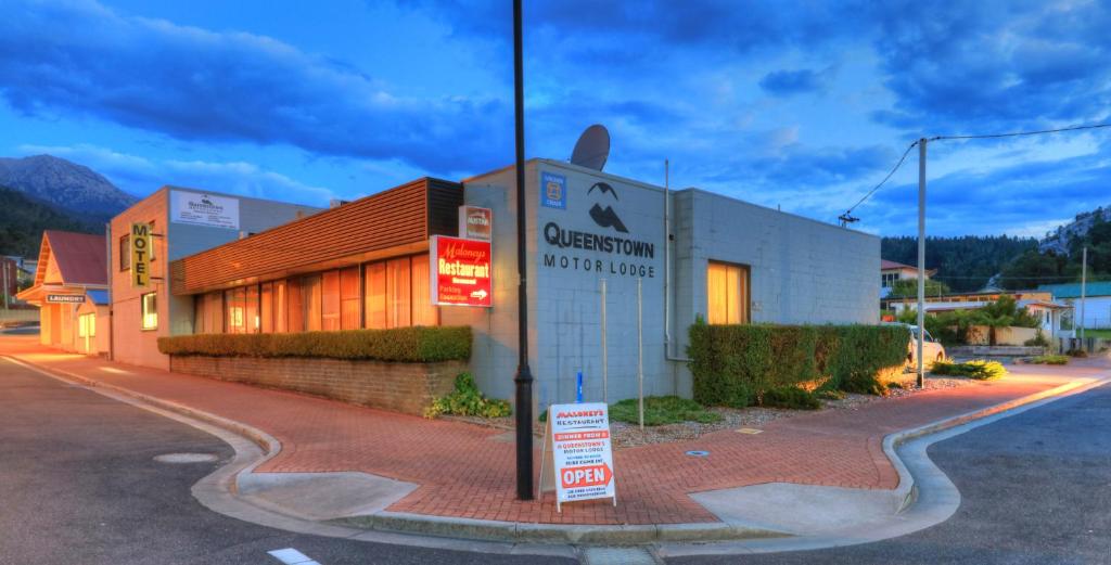 a building with a sign on the side of a street at Queenstown Motor Lodge in Queenstown