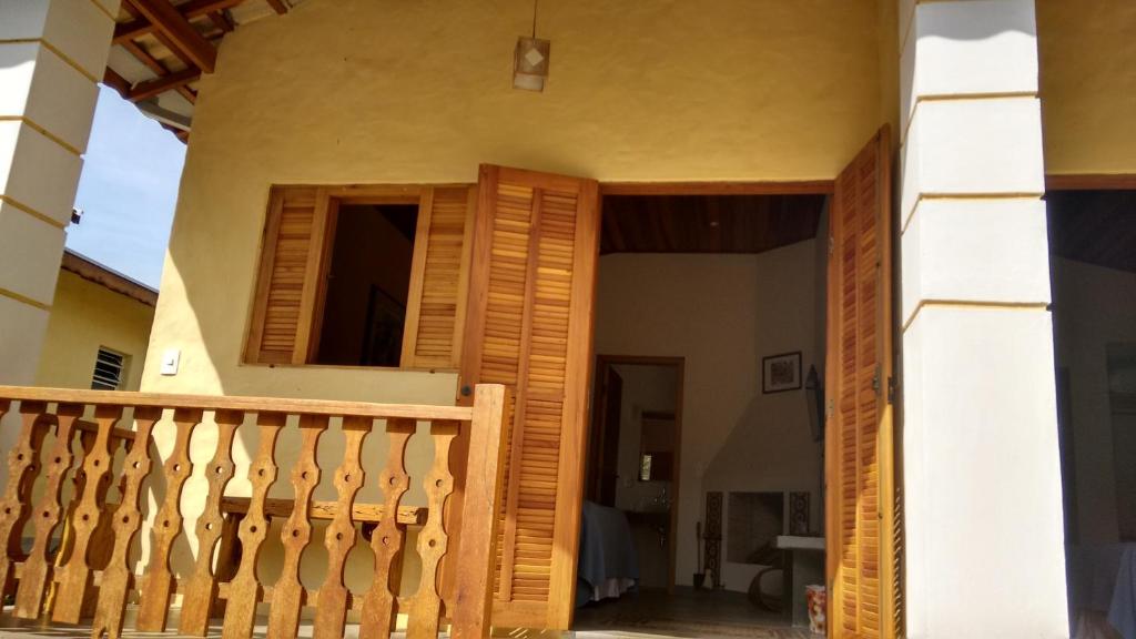 een balkon van een huis met een houten deur bij Pousada Morena SFX in São Francisco Xavier