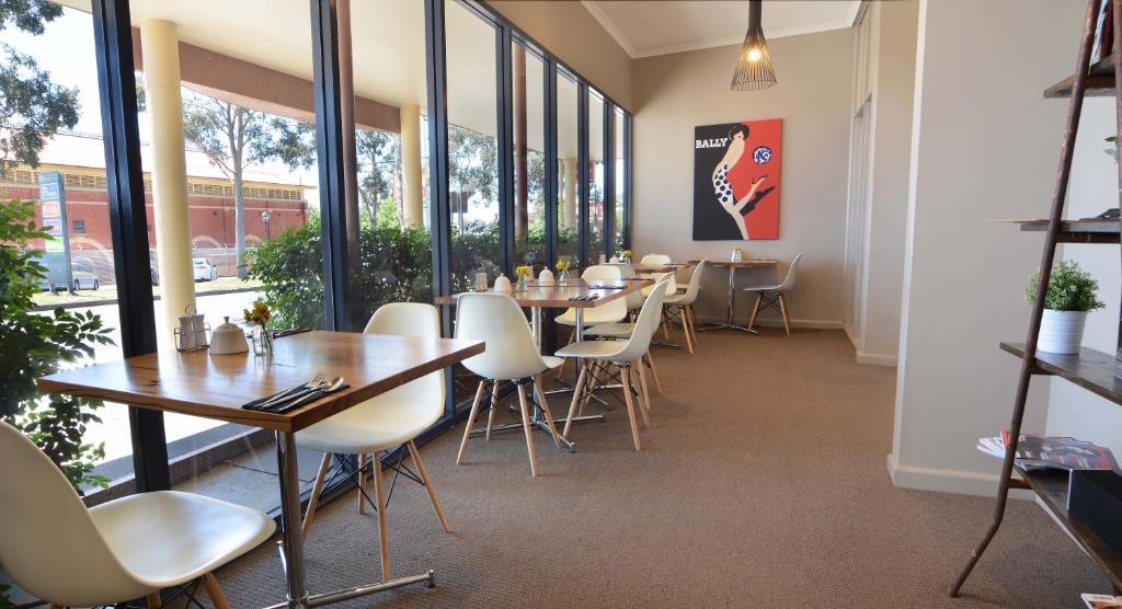 a dining room with tables and chairs and windows at Barclay On View in Bendigo