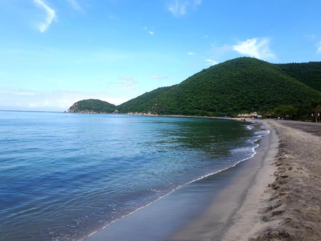a view of a beach with mountains in the background at Apartamento Frente al Mar in Santa Marta