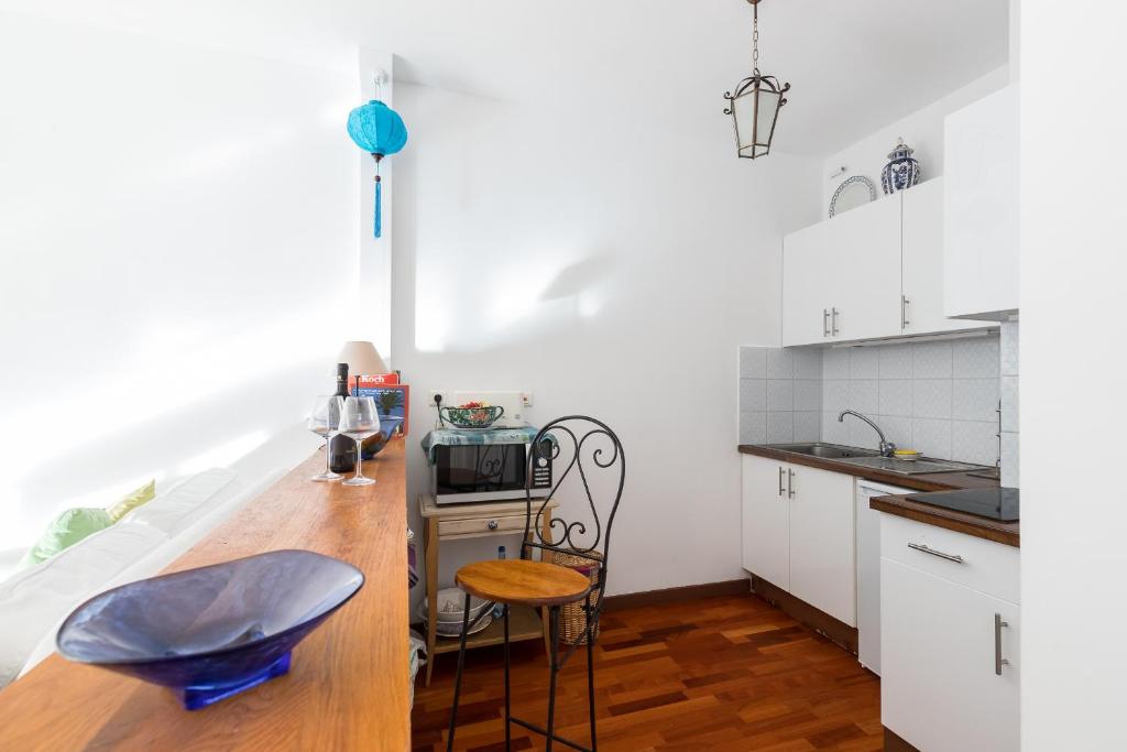 a kitchen with white cabinets and a wooden counter top at Appartement Nice Port in Nice