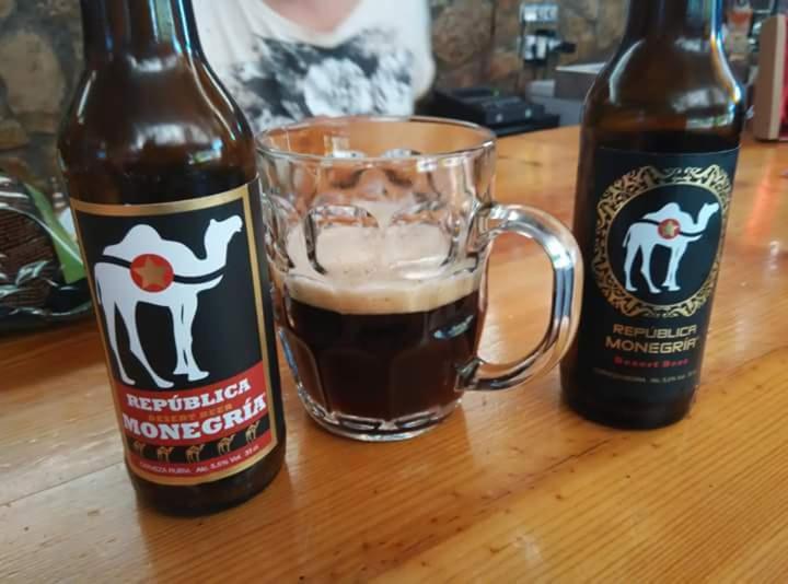 dos botellas de cerveza sentadas junto a una taza de café en Hotel Cueva Tardienta Monegros-Adults Only, en Tardienta