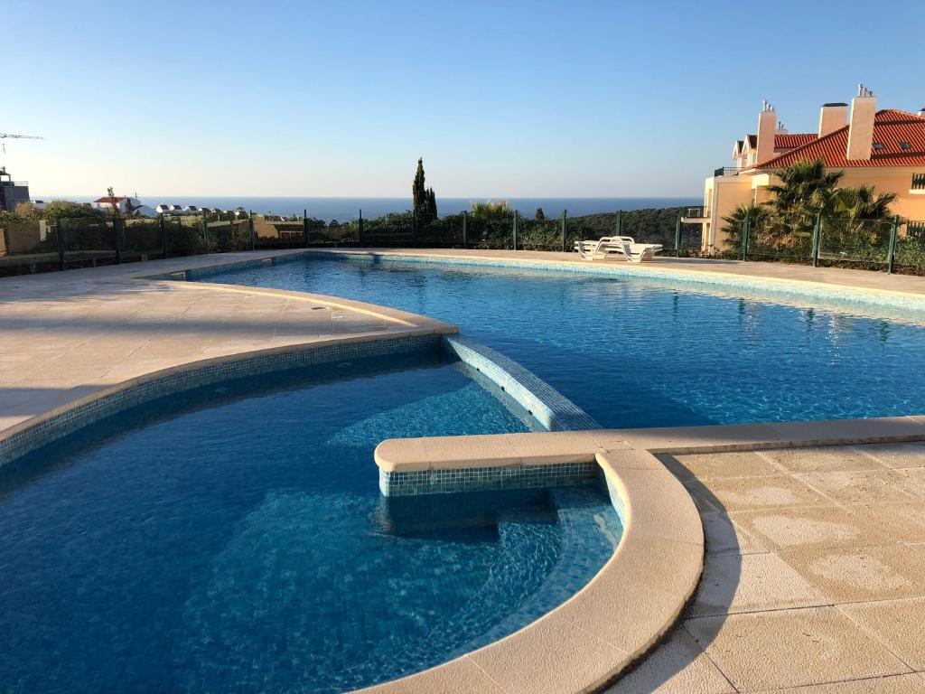 una gran piscina con un banco en el medio en Ericeira Luxury Apartment on a private condo, en Ericeira