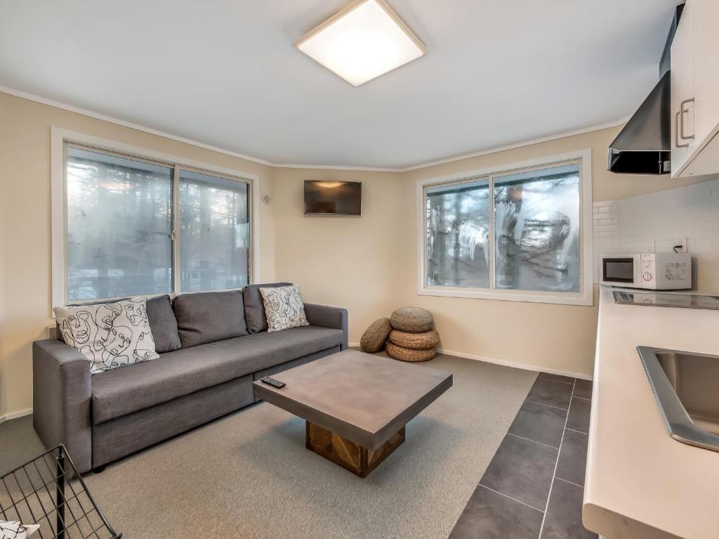 una sala de estar con un sofá y una mesa en Apartments Madarao, en Iiyama
