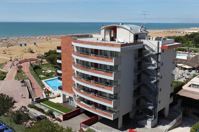 a large building with a pool in front of a beach at Residence Panorama Apart Hotel in Bibione