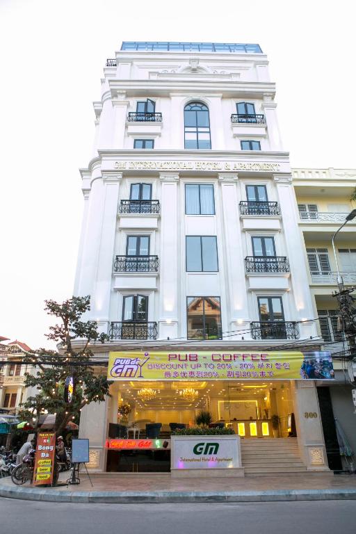 a white building with a store in front of it at GM Hotel and Apartment in Hai Phong
