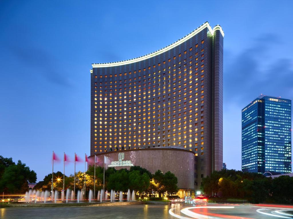 a tall building with a large clock on it's side at Hongqiao Jin Jiang Hotel (Formerly Sheraton Shanghai Hongqiao Hotel) in Shanghai