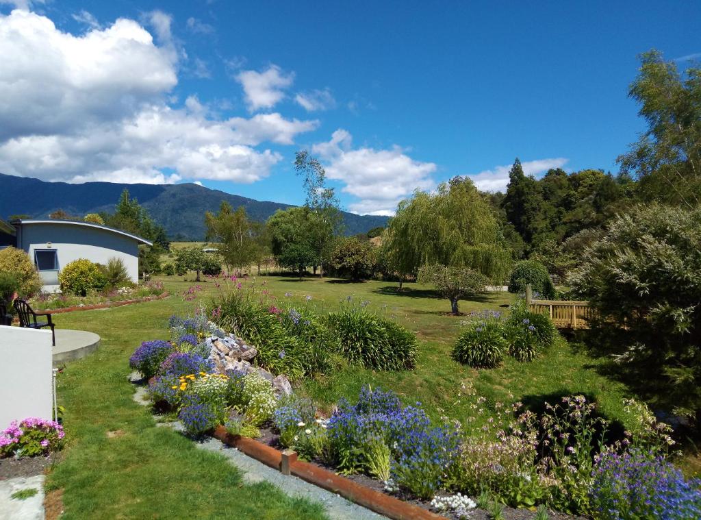 a garden with colorful flowers in a yard at Patons Rock Beach Villas in Takaka